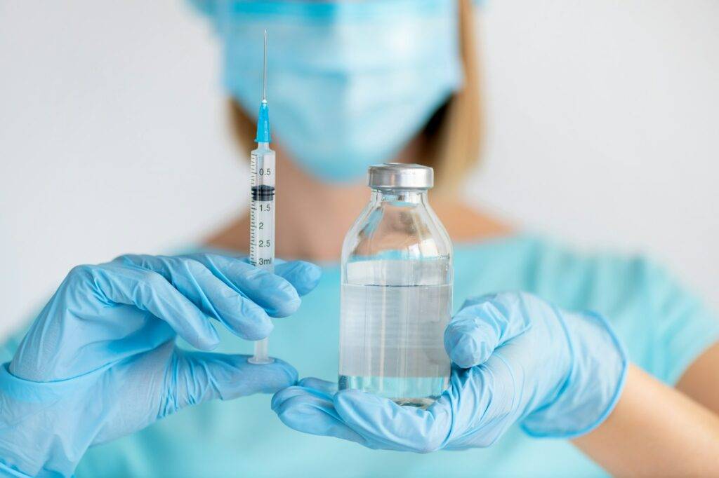 Bottle and syringe for injection in nurse hand